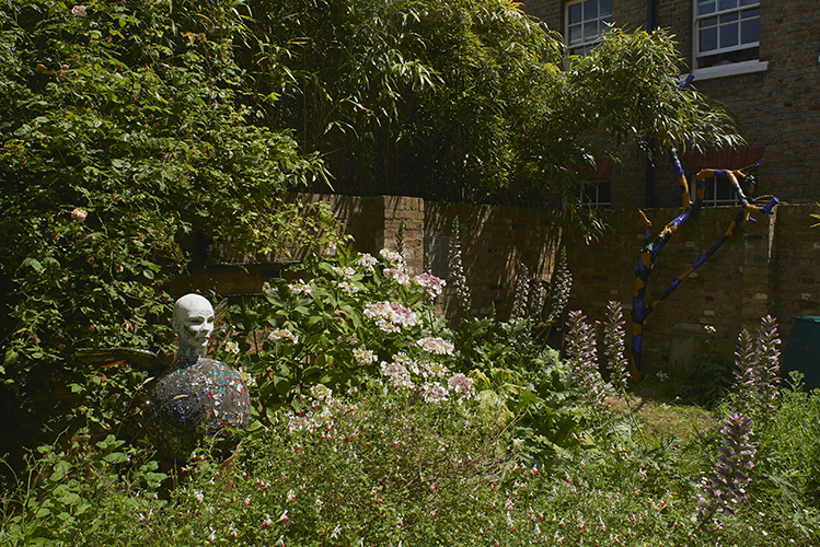 Andrew Logan 'Portrait of Jen' 1986, collection Jennifer Binnie, mixed media (left), Matt Hale 'Ceanothus no.31 Trunk series' 2019, Ceanothus tree (dead), acrylic paint, (right) photo by Andy Keate